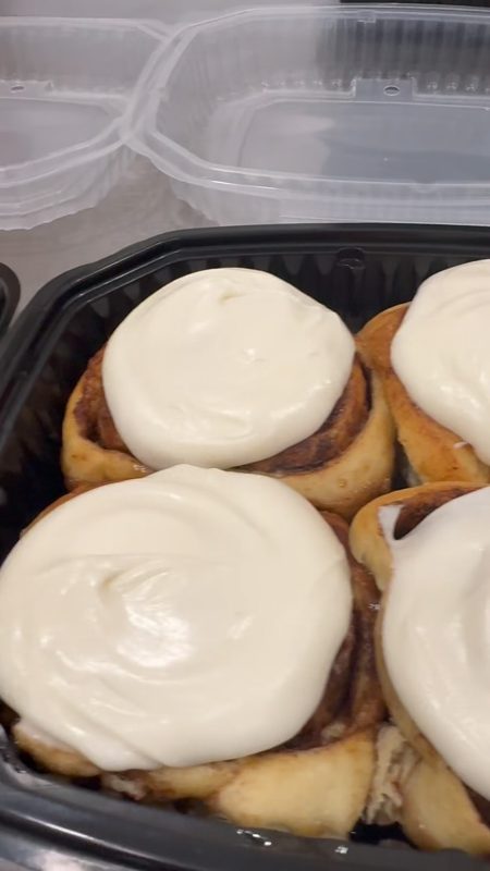 Container of cream cheese frosted cinnamon buns for National Cinnamon Bun Day