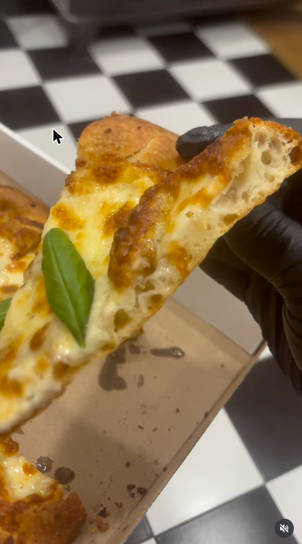 Slice of white pizza with fresh basil