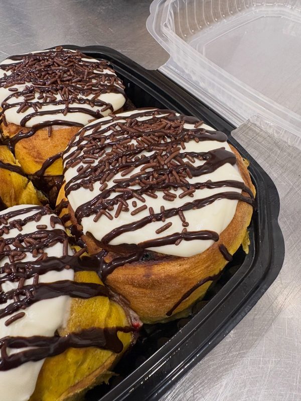 Pumpkin bun filled with chocolate funfetti, topped with icing, chocolate sprinkles, and chocolate drizzle